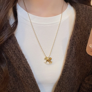 Detail of golden rocking horse necklace with tiger eye stone and white zircon on person