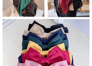 Macro detail of large satin bow hair clips in multiple colors for stylish hair styling