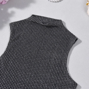 Détail d'un débardeur en maille à col montant avec texture noir et blanc et coutures fines