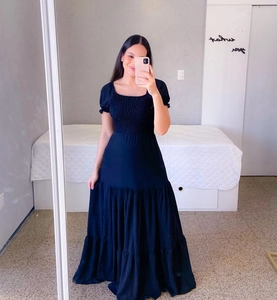 Detail of smocked elastic bodice and tiered skirt on a black floral maxi dress