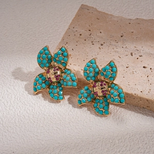 Detail of vintage flower stud earrings with turquoise beads and red crystal centers