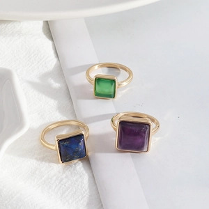 Macro shot of square-cut gemstone rings with emerald, lapis lazuli and amethyst textures