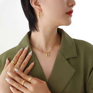 Golden padlock necklace set with purple zircon pendant and matching earrings and rings