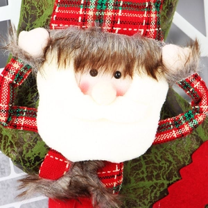 Detailed close-up of handmade Santa plush hanging with red and green plaid fabric pattern