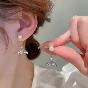 Detail of fishtail drop earrings with colorful rhinestones and white pearls on silver hooks