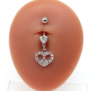 Close-up of heart-shaped angel wings belly ring with crystal stones on silicone model
