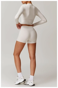 Vue arrière de l'ensemble de yoga crème avec short taille haute et haut à manches longues