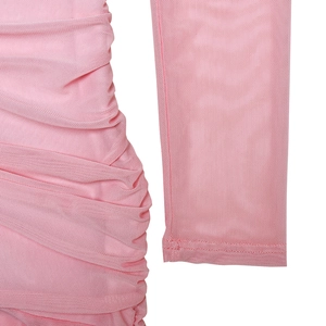 Détail de la robe en maille rose avec texture plissée et manches longues translucides