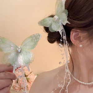 Detail of light green butterfly hair clip with elegant pearl tassels and bead fringe
