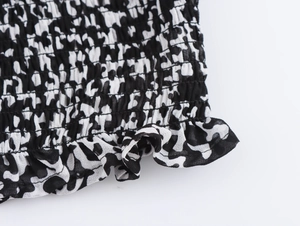 Dettaglio del tessuto in chiffon bianco e nero con orlo a balze e trama a pieghe