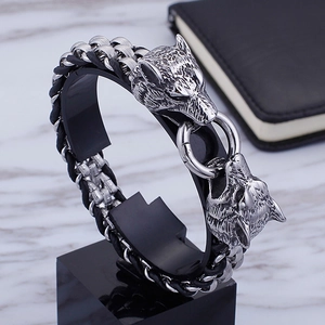 Detail of silver wolf head buckle and black braided leather strap on men's bracelet