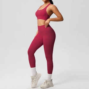 Vista lateral de un conjunto de yoga burdeos con leggings de cintura alta y top deportivo