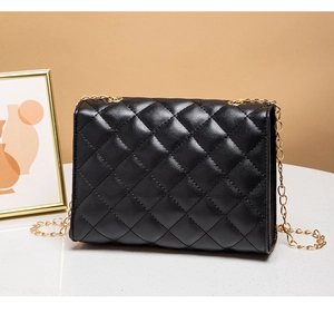 Detail of the black quilted crossbody bag with golden chain strap and buckle closure