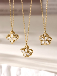 Close-up of three 18K gold-plated necklaces with clover and butterfly pendants set with zircon