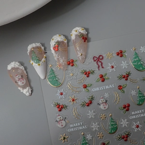 Gros plan de stickers à ongles 3D de Noël avec bonhomme de neige et motifs d'arbres dorés