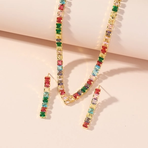 Close-up of golden necklace and earrings set with vibrant multi-color square zircons