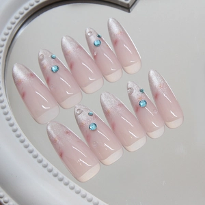 Cat eye press-on nails with sparkling rhinestones and French tip on a mirrored surface
