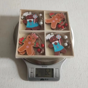 Set of four wooden gingerbread man Christmas ornaments in a natural wood storage box