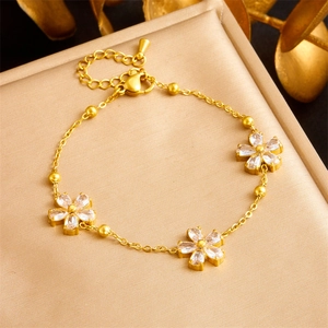 Elegant gold stainless steel bracelet featuring zircon flower pendants and lobster clasp