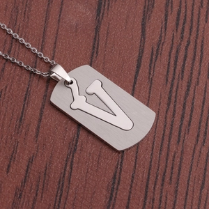 Gros plan d'un collier en acier argenté avec pendentif rectangulaire et la lettre V