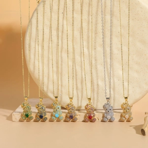 Gros plan de pendentifs ours colorés avec cœurs en zircon sur chaînes dorées et argentées