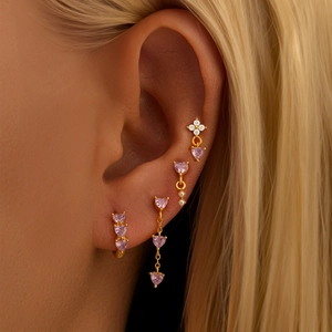 Close-up of pink heart zircon earring set in gold finish on a female model