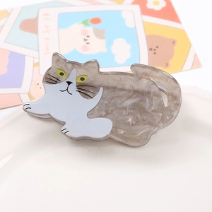 Macro shot of cute grey marble cat hair claw clip on a white ceramic plate