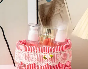 Close-up of red striped quilted storage bag with white lace trim and pink flower detail