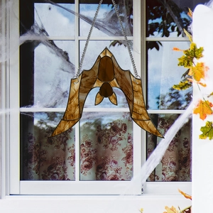 Macro detail of amber acrylic bat window suncatcher with metal chain for Halloween decor