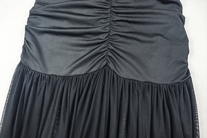 Detail of ruched black fabric with mesh panels and elegant tailored layering texture