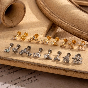 G23 titanium labret studs with zircon inlays in gold and silver set on vintage background