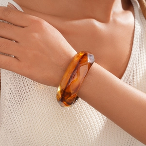Macro shot of geometric faceted acrylic bangle in amber tortoise shell resin pattern
