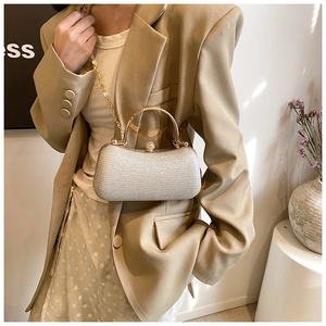 Detail of glitter evening box bag featuring gold handle, diamond clasp, and chain strap