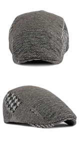 Detail view of grey wool flat cap showing houndstooth patchwork and stitching quality