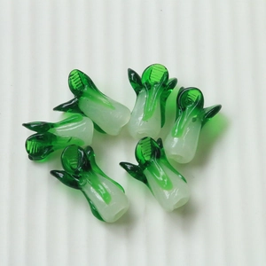 Macro view of six green and white glass cabbage charms for DIY jewelry making