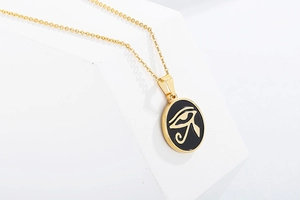 Detailed close-up of a gold Eye of Horus pendant on a black oval charm with fine gold chain