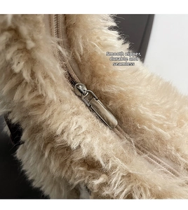 Close-up of the smooth metal zipper and soft beige faux fur texture on the shoulder bag