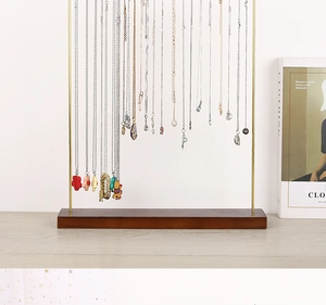Close-up of wooden and metal jewelry stand showcasing necklaces with various pendants