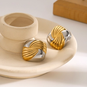 18k gold and silver two-tone square hoop earrings with wavy texture on ceramic tray