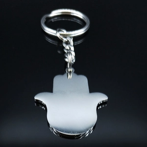 Polished stainless steel Hamsa Hand keychain with silver finish on reflective surface