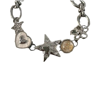 Close-up of silver bracelet with star, heart, and flower charms featuring rhinestones