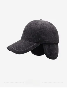 Detail view of winter baseball cap with ear flaps and thick knitted texture in dark grey