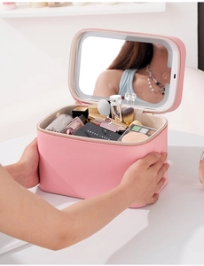 Pink PU leather makeup case with LED mirror held by hand to show portable size and design