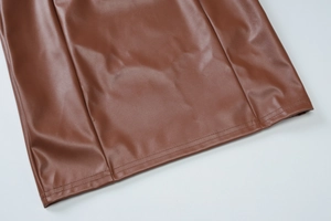 Details des braunen Lederkleides mit Textur und doppelter Naht am Saum der Damenmode