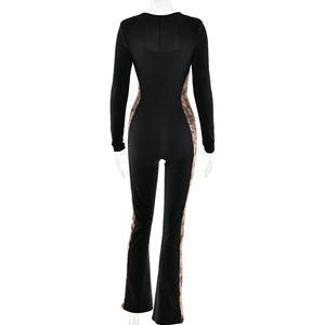 Detail view of back side lace patchwork and flared leg design on black jumpsuit