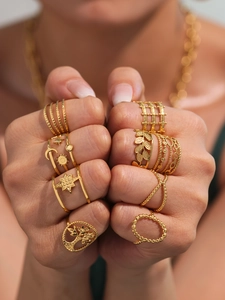 Close-up of golden multi-layer geometric ring set with star and moon motifs on hand