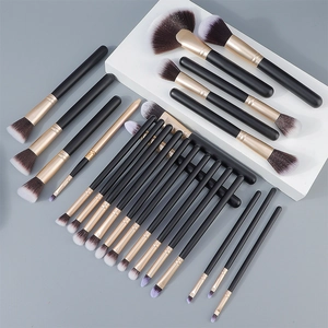 Macro view of professional black and gold makeup brushes with soft synthetic bristles