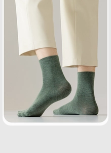 Close-up of grass green cotton crew sock texture worn by model with beige trousers