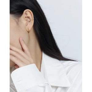 S925 sterling silver gold plated olive bead hoop earrings worn by a model on white background