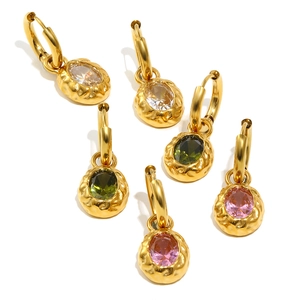 Three pairs of gold-plated hoop earrings with hammered metal texture and oval gemstones